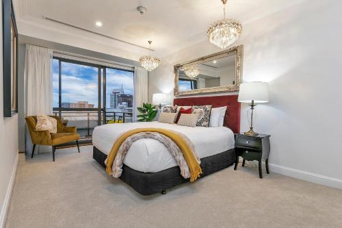 a bedroom with a large bed and a mirror at Royale Palace - Rooftop Pool &Spa in Auckland