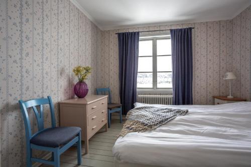 sypialnia z łóżkiem, 2 krzesłami i oknem w obiekcie Strandgården Fjällnäs w mieście Tänndalen