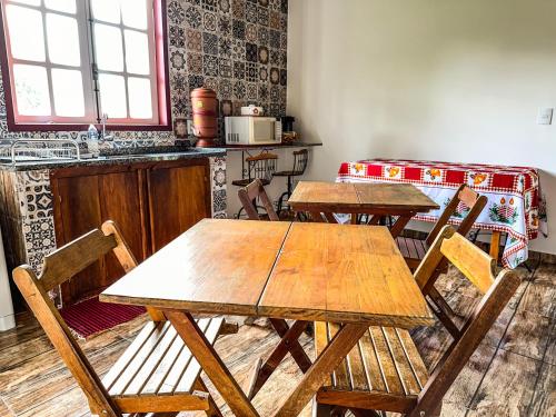 una cocina con mesas y sillas de madera en una habitación en Gruta d'ouro Pousada, en Prados