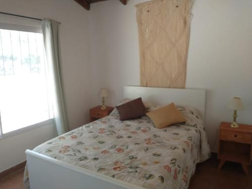 Un dormitorio con una cama grande con flores. en Casa Quinta Don Chilo, en San Pedro
