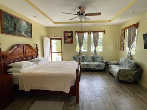 a bedroom with a bed and a ceiling fan at Hidden Treasure Vacation Home BayBlue Suite 1 in Belize City