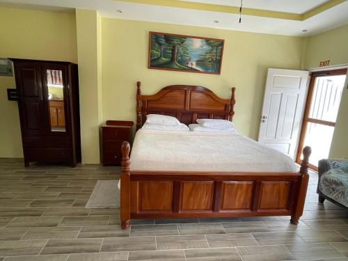 a bedroom with a wooden bed in a room at Hidden Treasure Vacation Home BayBlue Suite 1 in Belize City