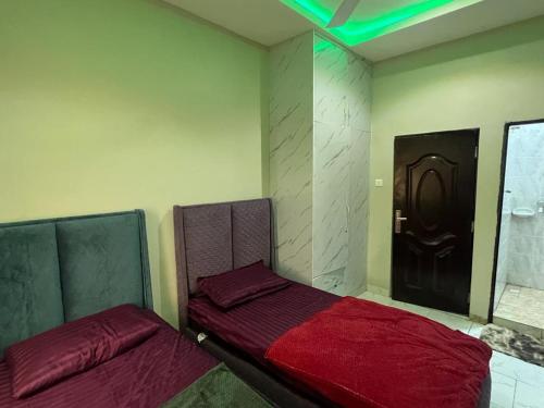 um quarto com duas camas e uma porta preta em Fowaa Luxury Square em Santeo