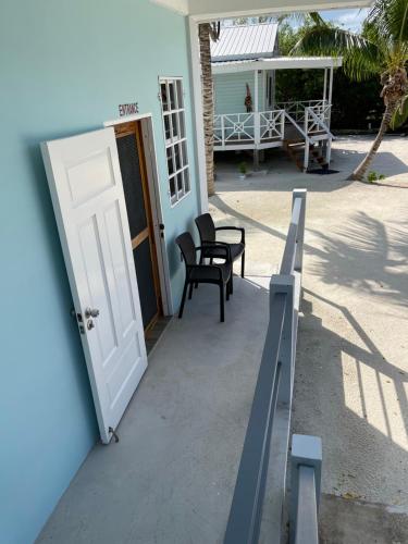 a door to a house with two chairs and a porch at Hidden Treasure Vacation Home BayBlue Suite 1 in Belize City