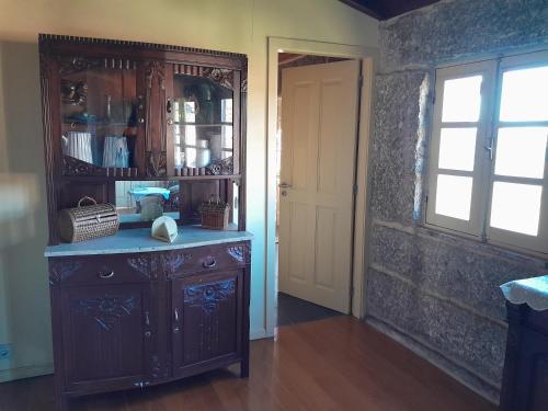 a kitchen with a wooden hutch and a window at Cantinho da Tilde in Fafe