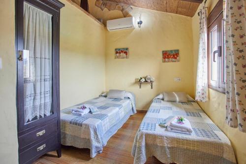 プラド・デル・レイにあるCasa Rural " Los Cuatro Olivos"のベッド2台と窓が備わる客室です。