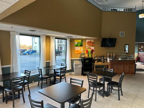 a restaurant with tables and chairs and a kitchen at Quality Inn in Ashland