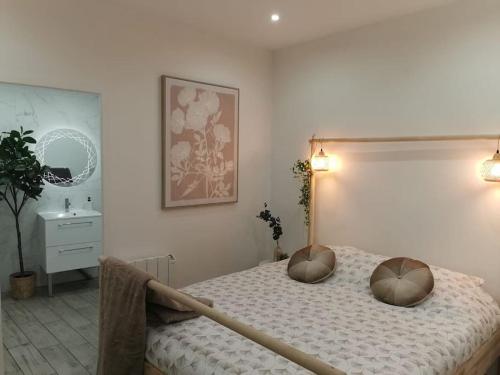 une chambre avec un lit avec deux oreillers dessus dans l'établissement L’Impérial au RDC, à Douai