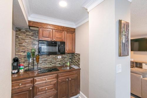 a kitchen with wooden cabinets and a microwave at High Rise Downtown Condo With Skyline View in Atlanta