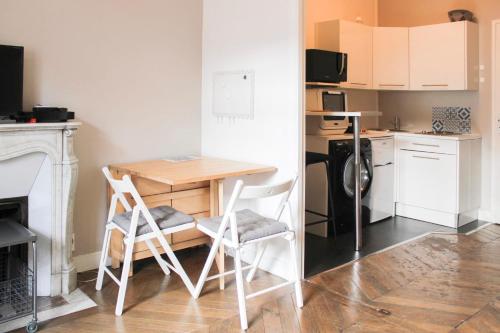 eine kleine Küche mit einem kleinen Tisch und Stühlen in der Unterkunft Cosy studio near Paris in Ivry-sur-Seine