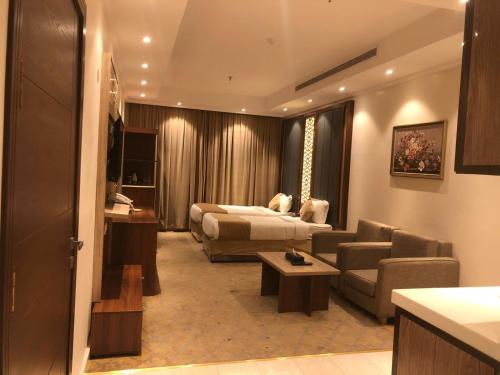 a hotel room with a couch and a bed and a table at درة العروس للوحدات السكنية المفروشة in Jeddah