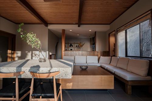 a living room with a table and a couch at AMAO VILLA 熱海 in Atami