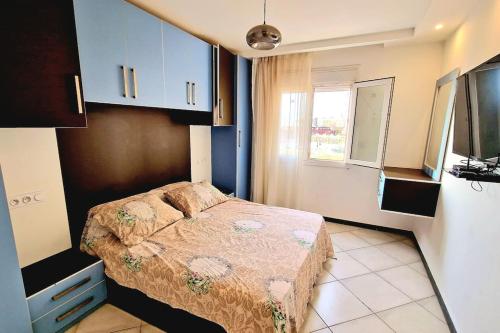 Dormitorio pequeño con cama y TV en F2 haut-standing akid lotfi, en Orán