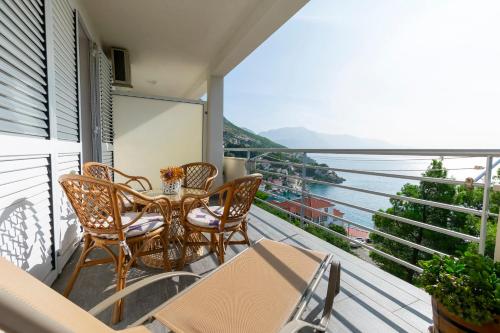 a balcony with a table and chairs and a view of the water at Apartments Olive sea view in Mimice