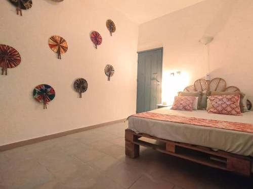 een slaapkamer met een bed en een aantal borden aan de muur bij Appartement cosy Cotonou 1 chambre in Cotonou
