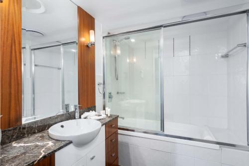 a white bathroom with a sink and a shower at Ocean Views at Surfers Paradise - Chevron Renaissance - 2 Bedroom Apartment - Wow Stay in Gold Coast