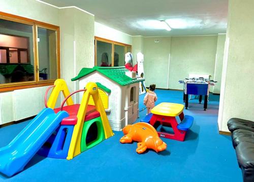 a child playing in a play room with a toy house at NWT Roccaraso - Casa Vacanze in Roccaraso