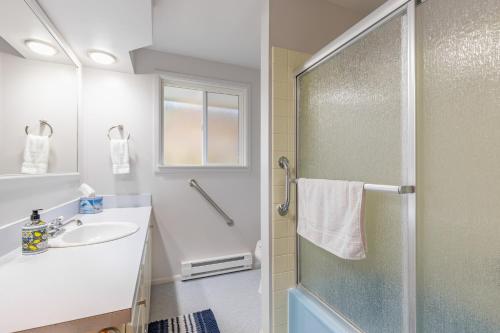 uma casa de banho com um chuveiro e um lavatório. em Whidbey Bliss by AvantStay 2min to Beach View em Greenbank