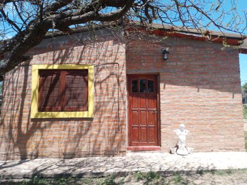 un pequeño edificio de ladrillo con una estatua al lado de una puerta en La Vuelta del Río en Panaholma