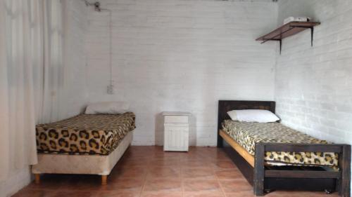 two beds in a room with white walls at La Vuelta del Río in Panaholma