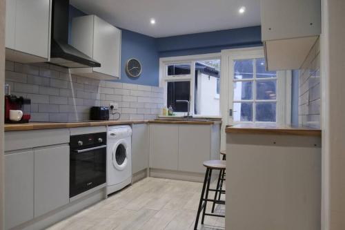 a kitchen with a washer and dryer in it at The Butcher's Block in Puckeridge