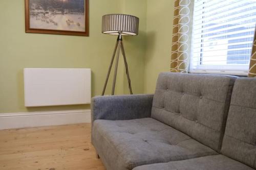 a living room with a couch and a lamp at The Butcher's Block in Puckeridge