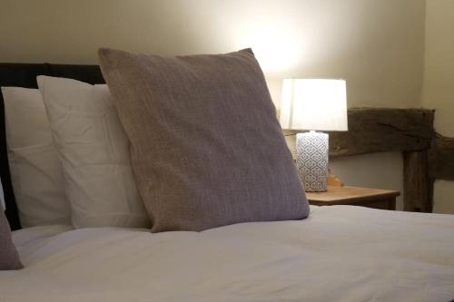 a bed with a pillow and a lamp on a table at The Butcher's Block in Puckeridge