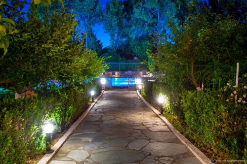 a walkway with lights in a garden at night at Hotel Europa Olympia in Olympia