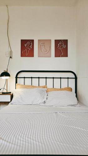 łóżko w sypialni z trzema obrazami na ścianie w obiekcie City Nest w mieście Iloilo