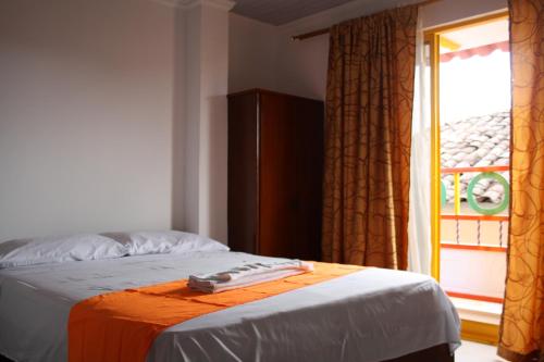 um quarto com uma cama e uma janela com em Hotel Balcón Plaza em Belalcázar