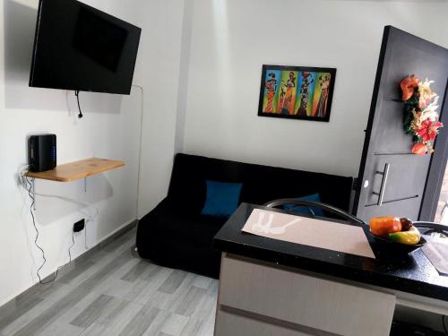 メデジンにあるEl refugio paisaのデスクとソファ付きの小さな客室です。