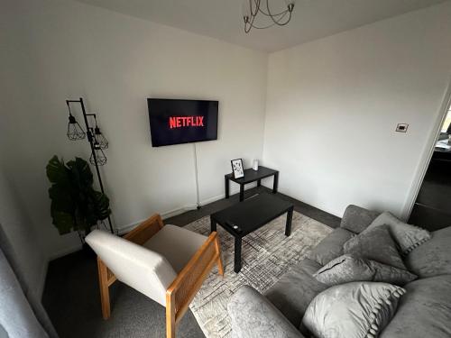 a living room with a couch and a tv at Timber Court Apartments in Central Location with FREE Parking and Netflix by RockmanStays in Stifford