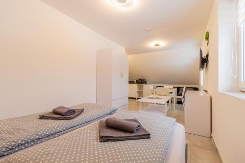 Habitación blanca con 2 camas y mesa en LIPNO Moss Apartment en Lipno nad Vltavou