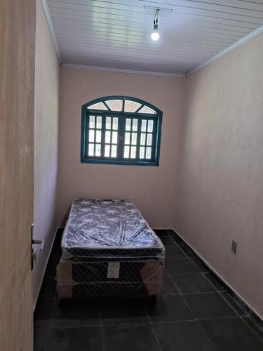 Zimmer mit einem Bett in einem Zimmer mit einem Fenster in der Unterkunft Casa Laranja in Angra dos Reis