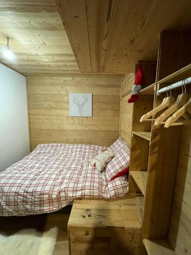 Cette petite chambre en bois comprend un lit. dans l'établissement Très bel appartement spacieux, aux Carroz d'Arâches