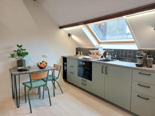 a kitchen with a table and a sink and a window at Studio Bink in Maastricht