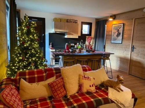 Una sala de estar con un árbol de Navidad y un sofá. en Très bel appartement spacieux, en Les Carroz d'Araches