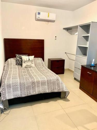 a bedroom with a bed with a wooden headboard at Departamento Regiomontano in Monterrey