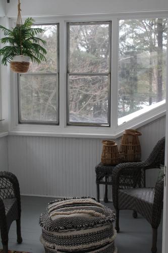 ein Zimmer mit zwei Stühlen, einer Topfpflanze und zwei Fenstern in der Unterkunft The Master Bedroom at the Hillside B&B in Wisconsin Dells