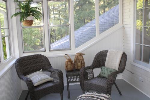 two chairs sitting on a porch with windows at The Master Bedroom at the Hillside B&B in Wisconsin Dells