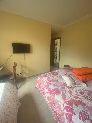 - une chambre avec un lit et une télévision murale dans l'établissement Apartamento 1 quarto 400m da praia de Taperapuan, à Porto Seguro