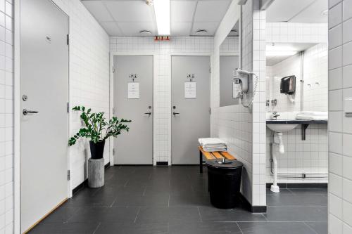 a bathroom with two stalls with a bench and a sink at Sure Hotel by Best Western Stockholm Alvsjo in Stockholm