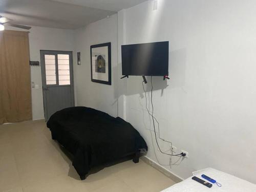 a bedroom with a bed and a flat screen tv on the wall at Alojamiento completo de descanso in Monterrey