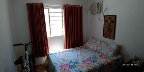 a bedroom with a bed and a window and a bike at Mar e Descanso in Maceió