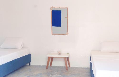 a room with two beds and a table with a mirror at La Marina Hostal in Ríohacha