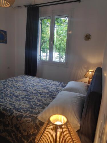 een slaapkamer met een bed en een raam bij Το σπίτι με τις βουκαμβίλιες in Ayia Evfimia