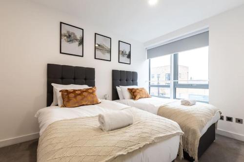 dwa łóżka w pokoju z oknem w obiekcie Lotus - Sleeps 5 w mieście Bracknell