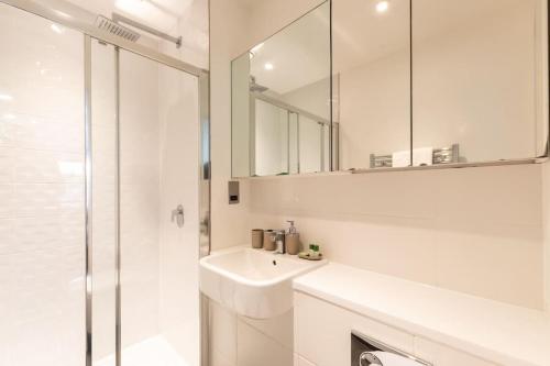 a white bathroom with a sink and a shower at Lotus - Sleeps 5 in Bracknell