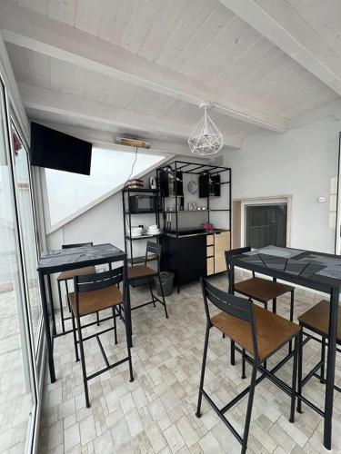 a room with tables and chairs and a kitchen at Giufra in Bari