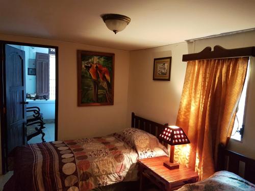 um quarto com uma cama e um candeeiro sobre uma mesa em HotelCasaMorazanGranadaNicaragua em Granada